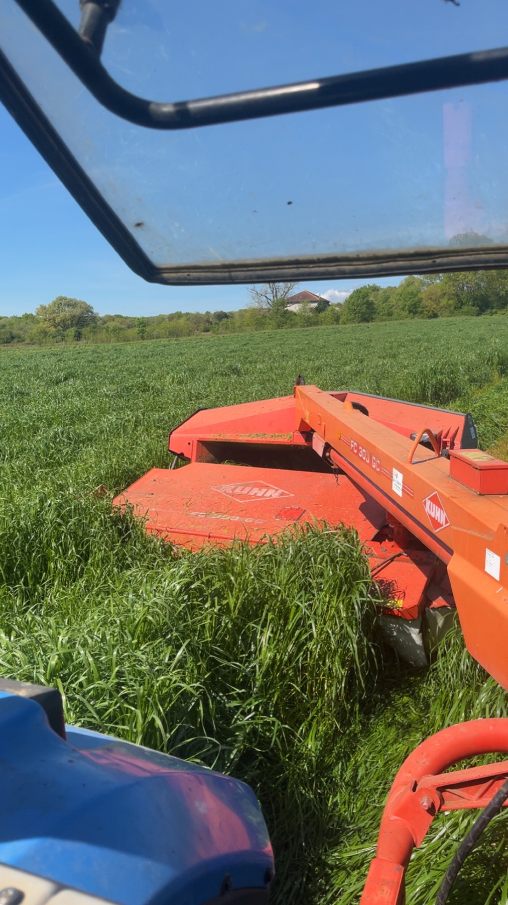 Faucheuse en action vue depuis la cabine du tracteur